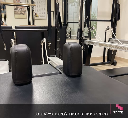 ריפוד שחור על מכשיר כושר עם ידיות מתכת